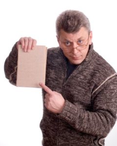 The man in glasses shows a finger on the book on a white background